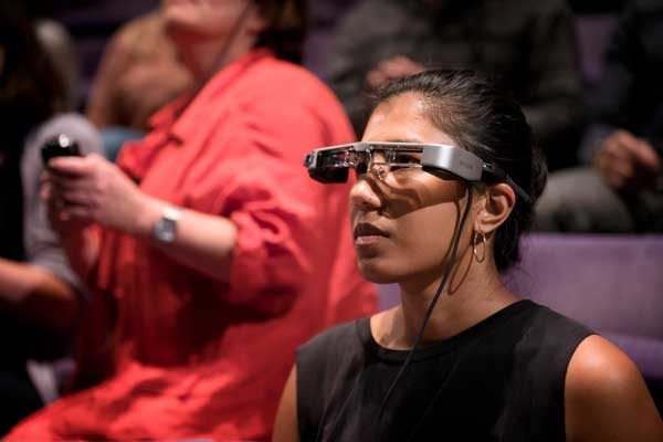 A photograph of a women wearing smart glasses