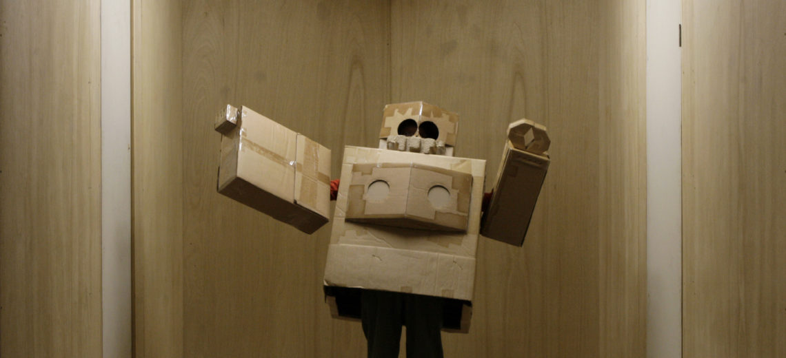  A person dressed in a robot costume made out of cardboard boxes