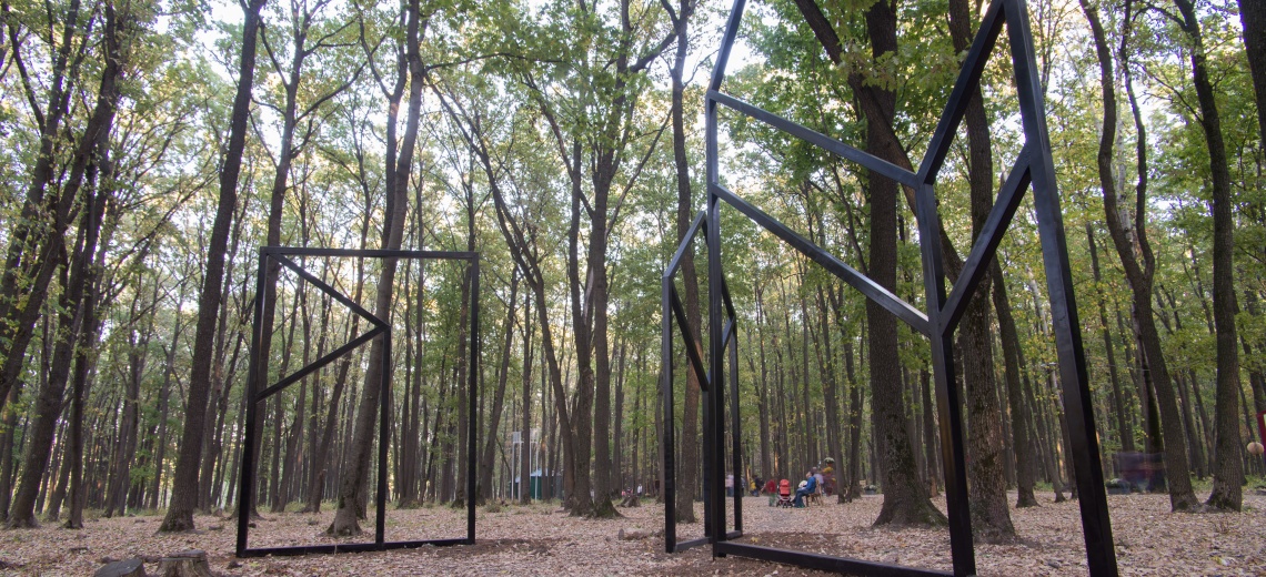  Three large square steel structures erected amidst tall trees. 