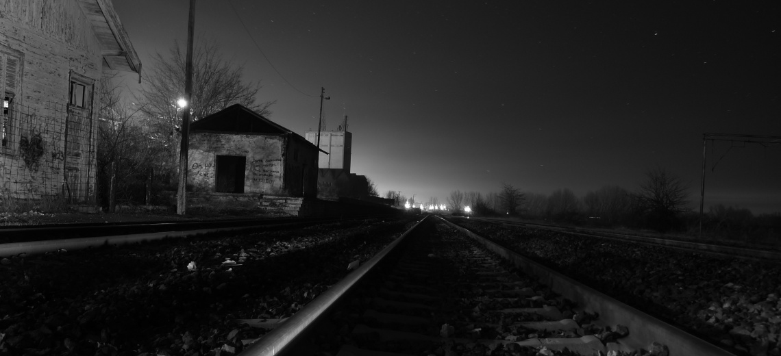 A railway track with outbuildings to the left. 