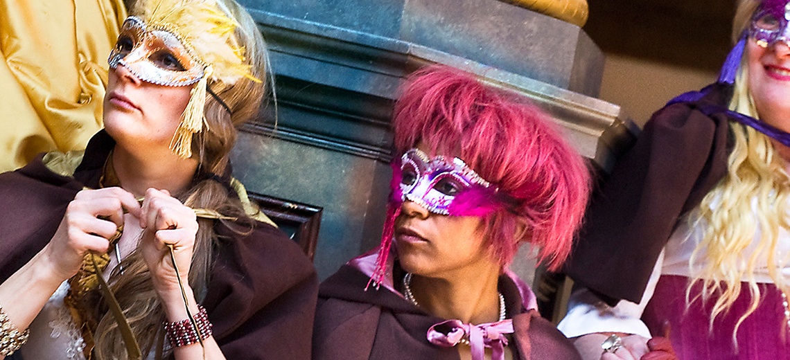 Three people wearing Venetian style eye masks. 