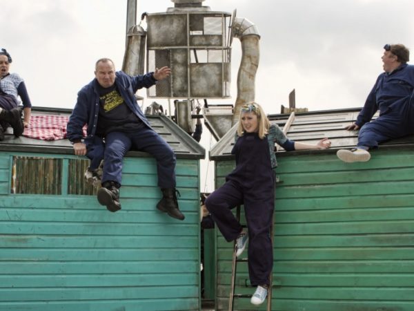 Four actors on shed roofs.