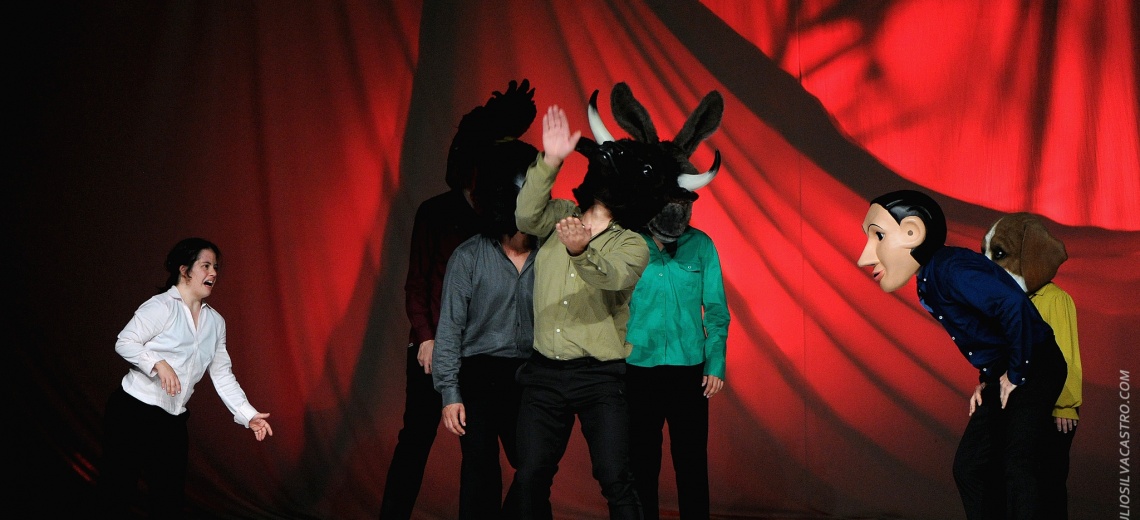  Seven performers on a stage. Some are wearing animal heads. 