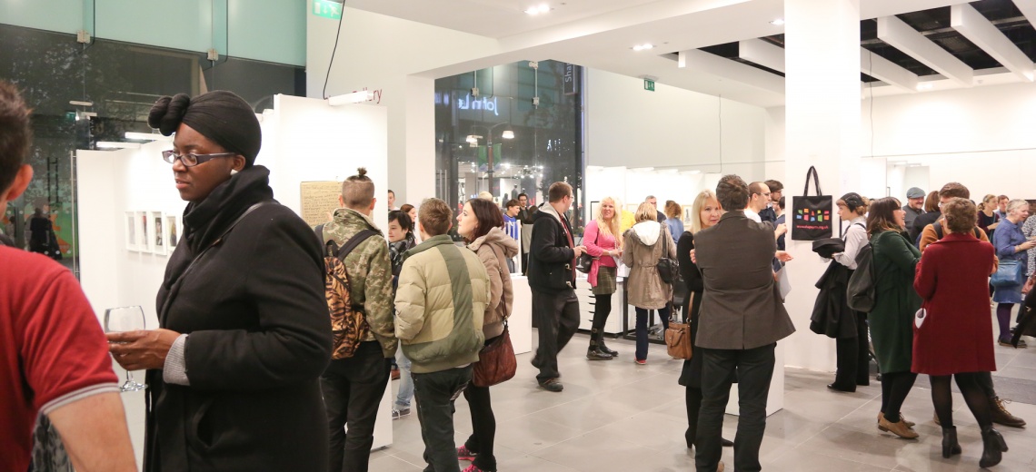 People walking around a white walled gallery