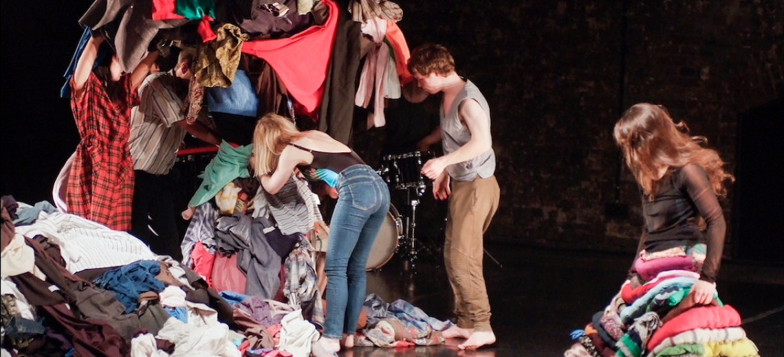 Performers sort through a huge pile of clothes