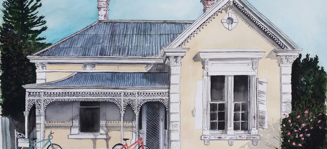 The front of a grand Victorian house with two bicycles resting against the porch. 