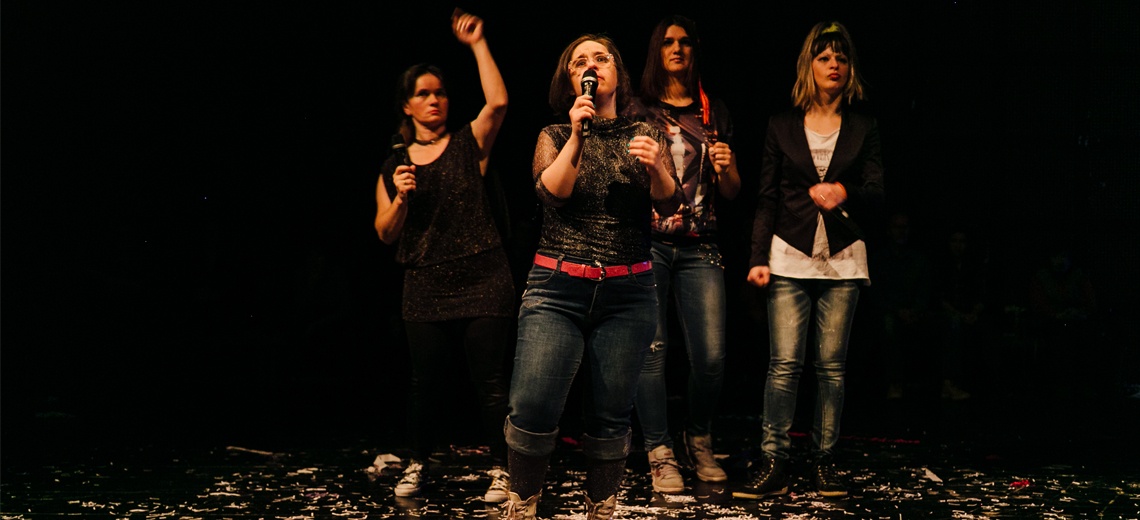 A singer on stage with three performers in the background. 