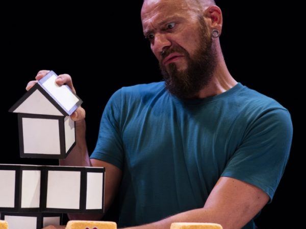 A man holding a house shaped box.
