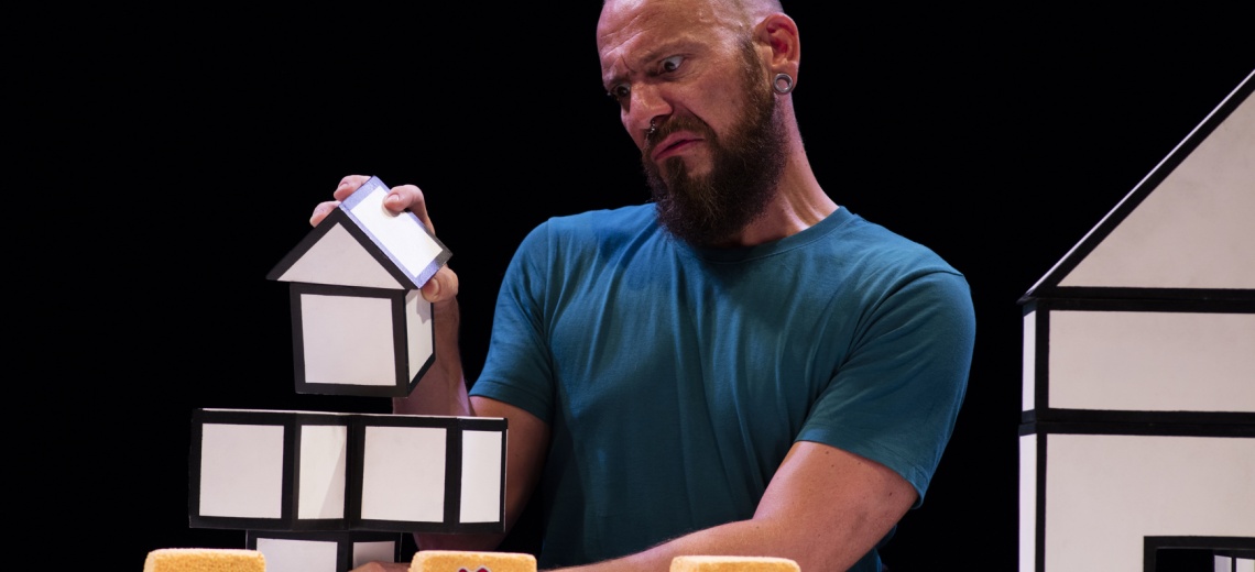 A man holding a house shaped box. 