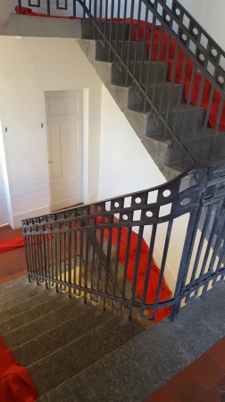 Photograph of a red dress flowing down a staircase