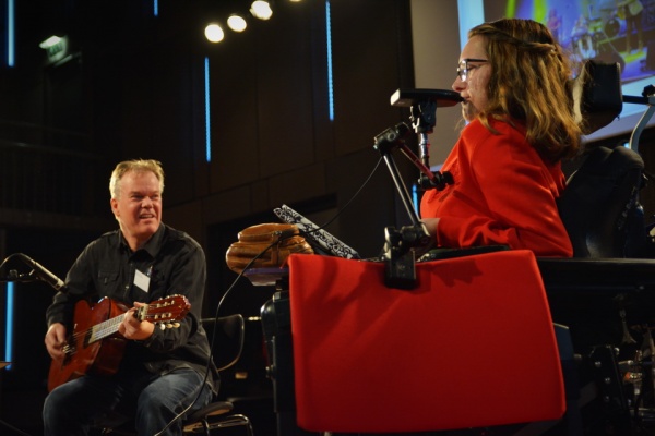 A wheelchair user plays a specially adapted instrument with her mouth