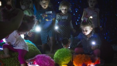 Group of children with torches explore a set