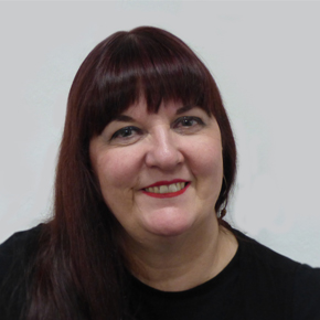 Portrait photo of Ruth Gould wearing black top, dark dear with fringe, smiling