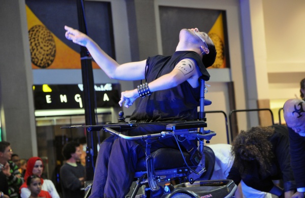 Photo of a wheelchair-user performing on stage
