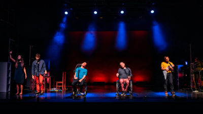 5 performers on a colourfully lit stage