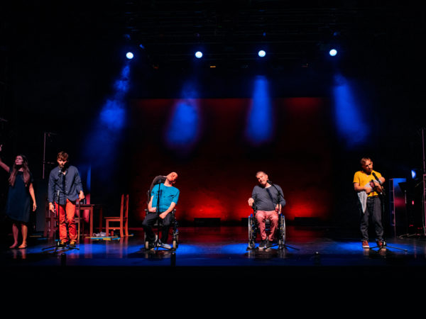 5 performers on a colourfully lit stage