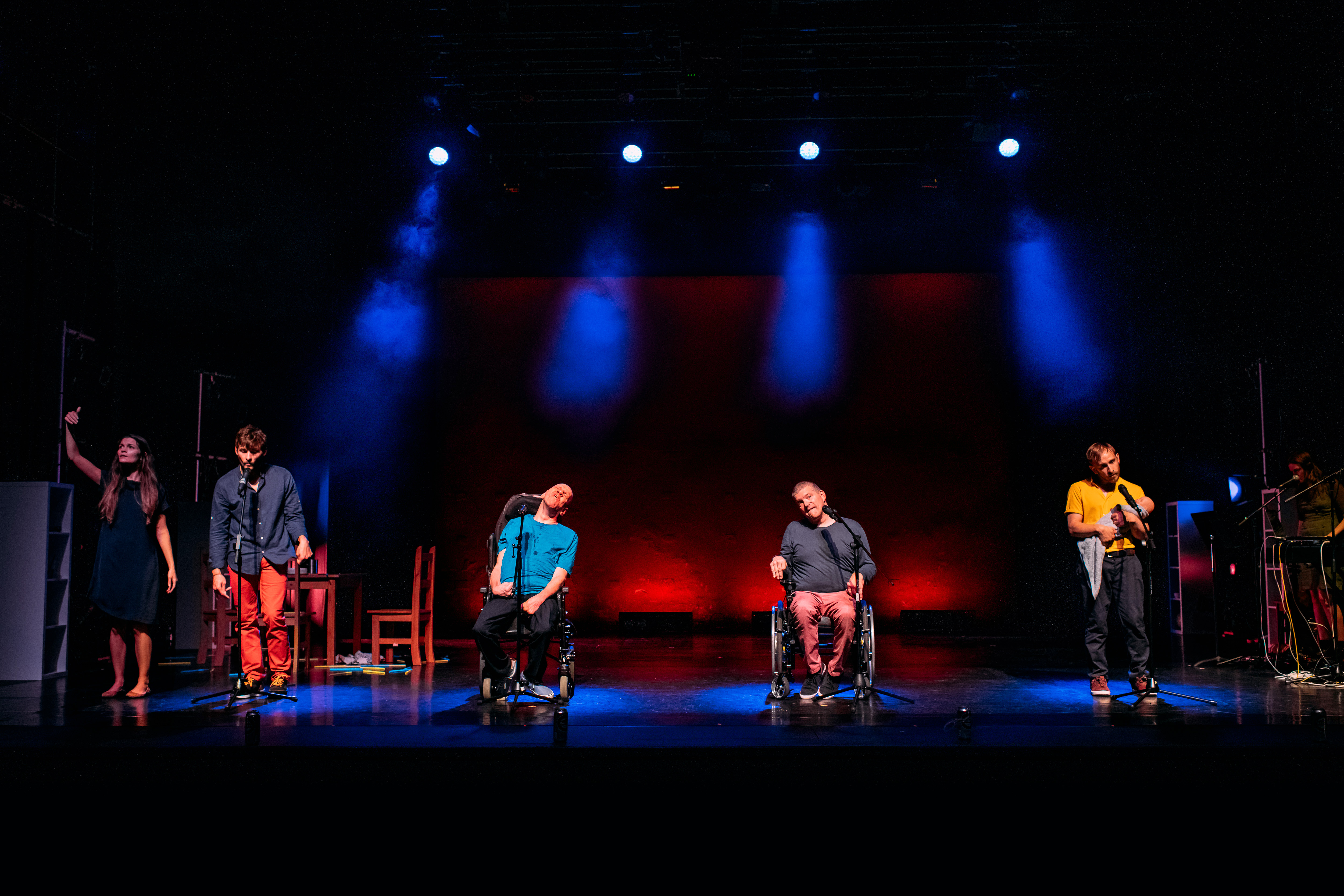 5 performers on a colourfully lit stage