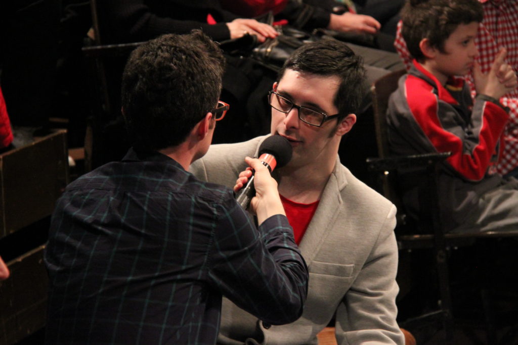Man holding a microphone up to a learning disabled man