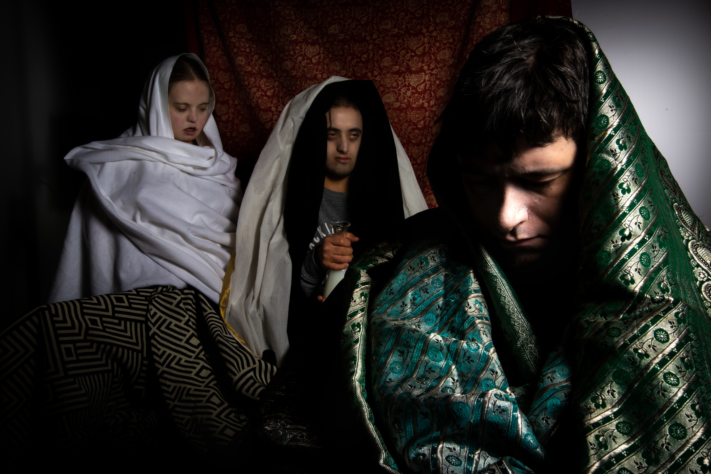 3 learning disabled people sit wrapped in shawls