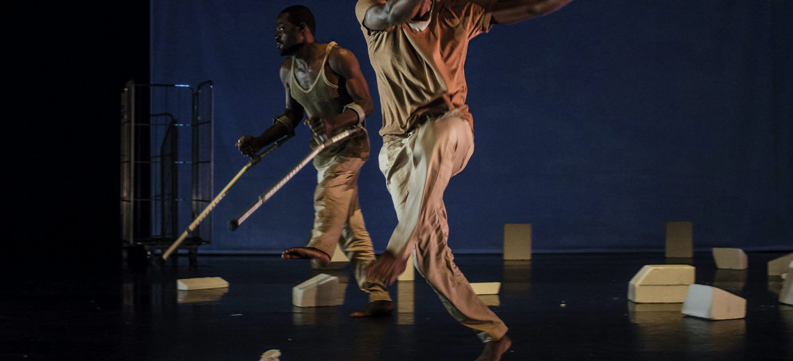 Two dancers in action on stage, one of them dance with crutches.