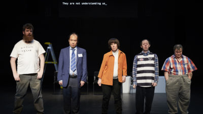 5 disabled performers stand in a line on stage