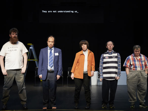 5 disabled performers stand in a line on stage