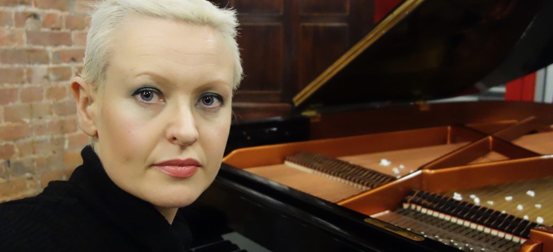 Woman with short hair sitting at piano