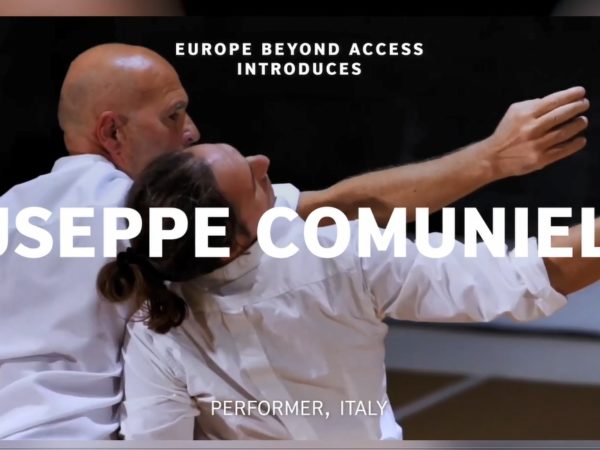 Two men in white shirts dance together, Giuseppe with long dark hair tied up