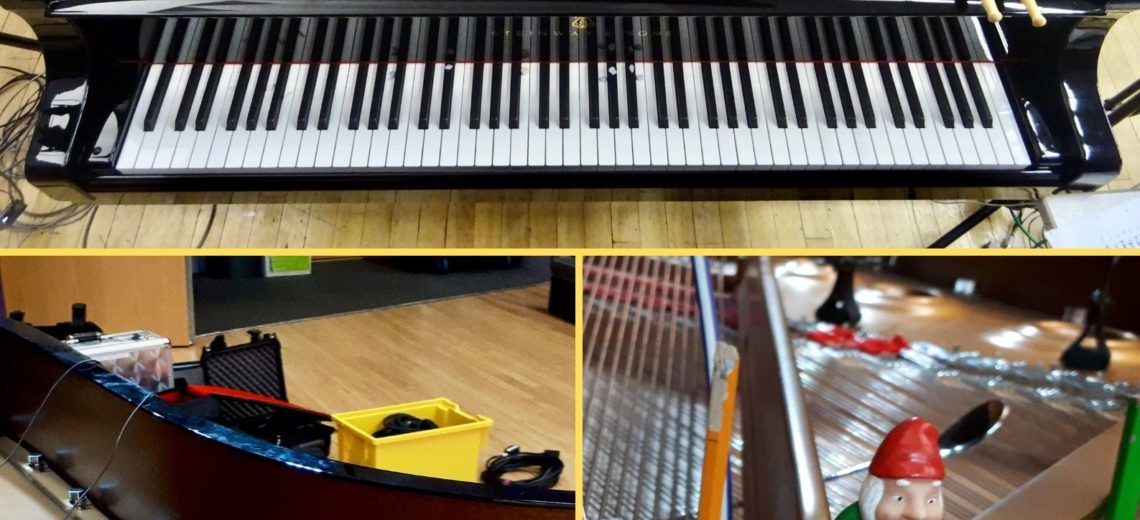 Inside of a grand piano with long strings. Pencil and other objects inside