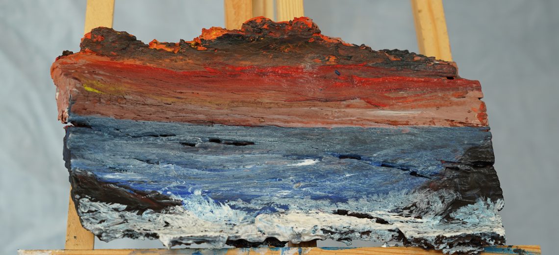 Photograph of a painting of a seaside scene done on a piece of driftwood.