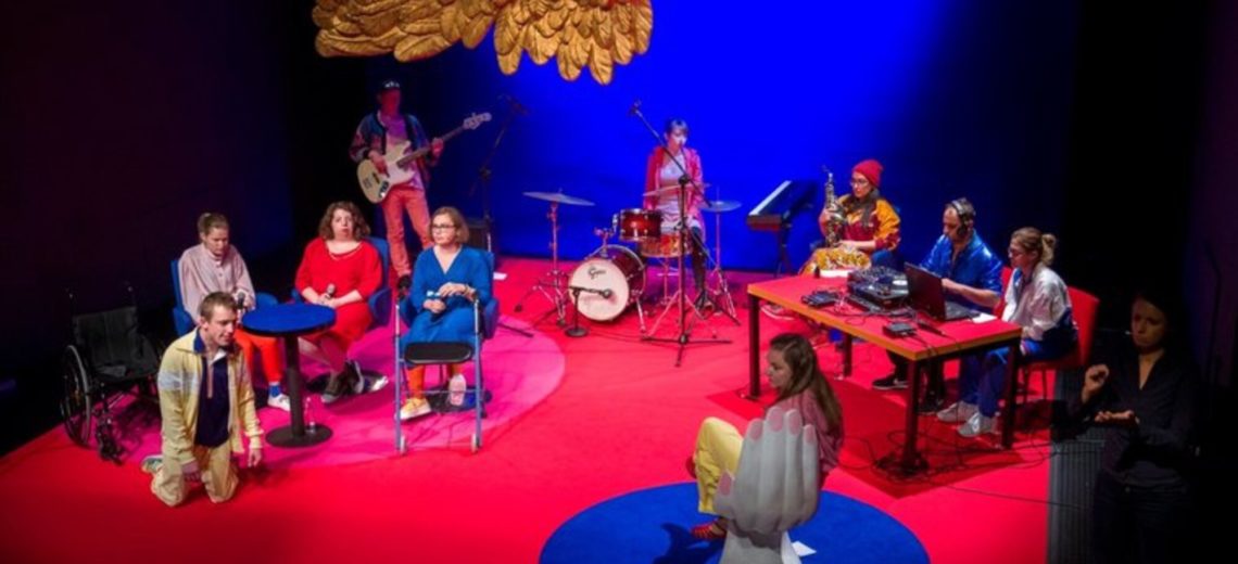A plush red floor and blue-lit scene features an ensemble of diverse musicians