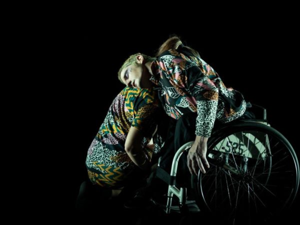 Two performers with leopard print clothes embrace tenderly