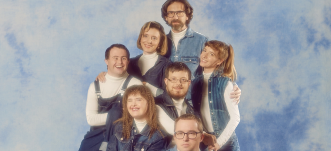A family portrait with everyone smiling against a fuzzy blue background