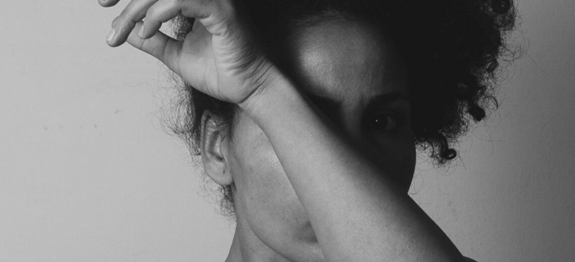 A woman with her arm covering her face