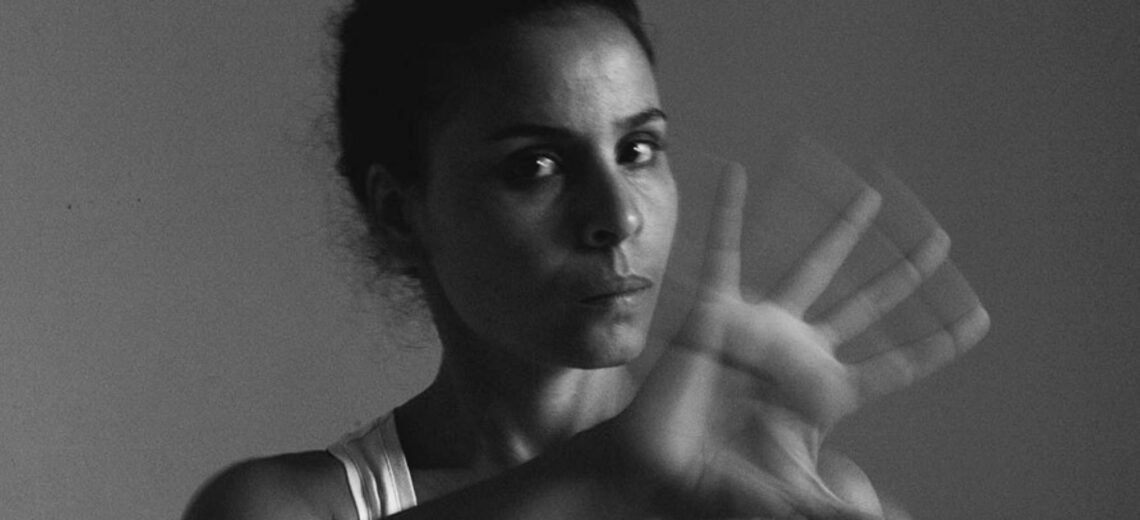 A woman with her hand blurred in front of her